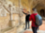 guide showing visitor artifacts on side of wall