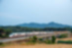 train on bridge with hills in distance